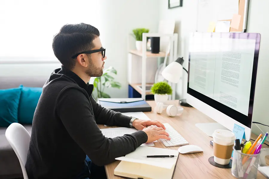 Mann sitzt am Computer am Schreibtisch